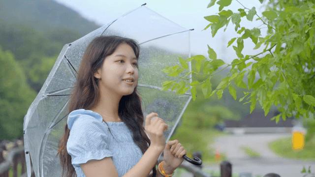 우산을 들고 비 오는 날을 즐기는 여성