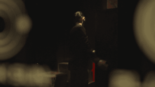 A man in a suit in a dimly lit room