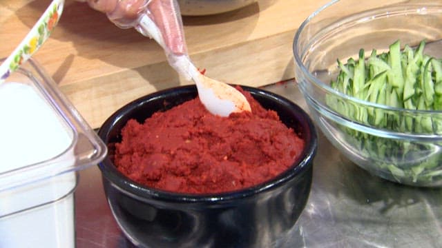 Putting red pepper marinade into a bowl