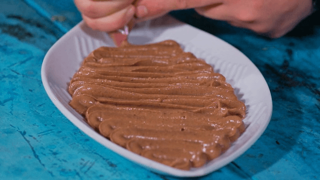 접시에 초콜릿 무스를 짜는 모습