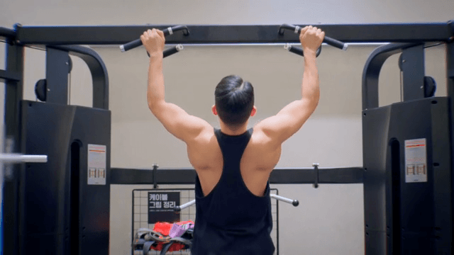 헬스장에서 턱걸이하는 남성