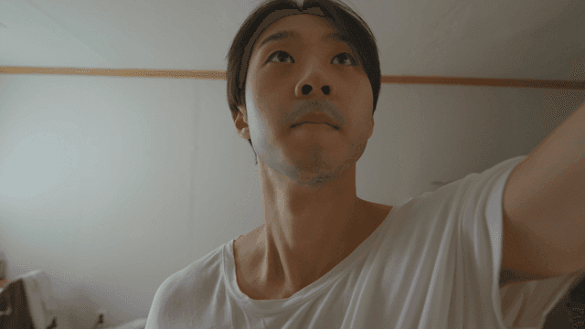 Man looking up and reaching out his hand in a room