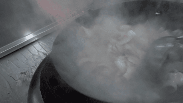 Meat stir-fried in hot wok with flames