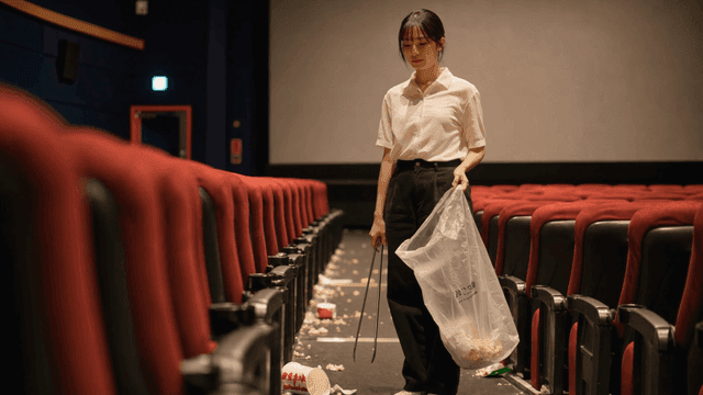 더러운 영화관을 청소하다 한숨을 쉬는 여성