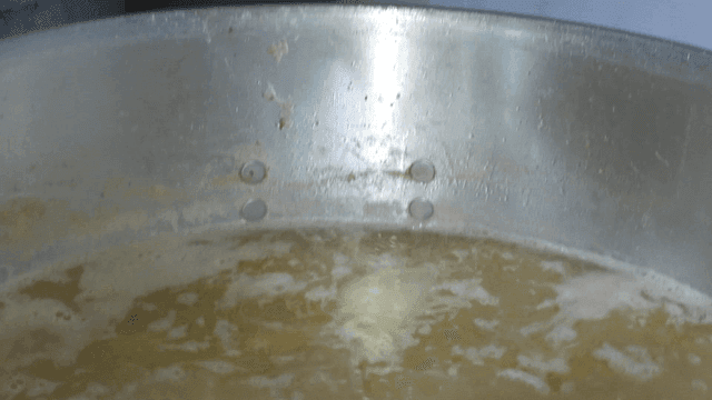 육수가 담긴 냄비에서 채소를 건져내는 채망