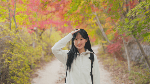Young woman smiling while enjoying autumn foliage