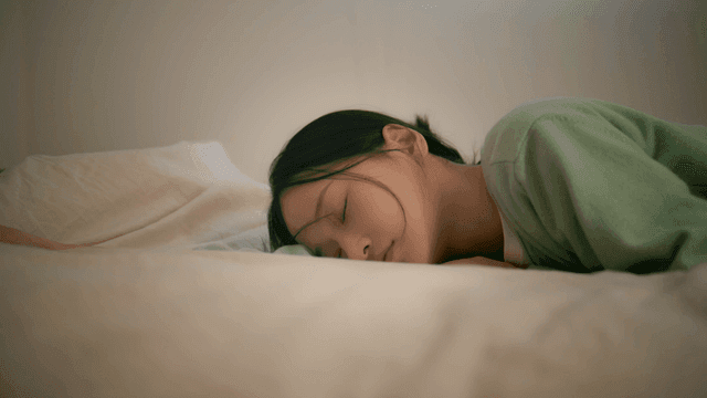 Young woman lying peacefully asleep in bed