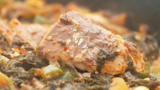 Appetizing braised mackerel with dried radish greens simmering in a pot