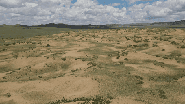 구름 낀 하늘 아래 광활한 사막 풍경