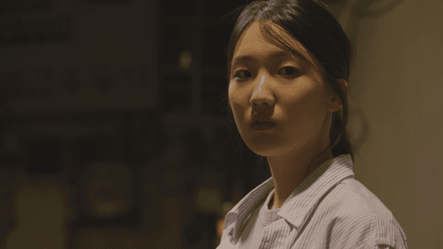 밤에 가로등 아래 서 있는 여성