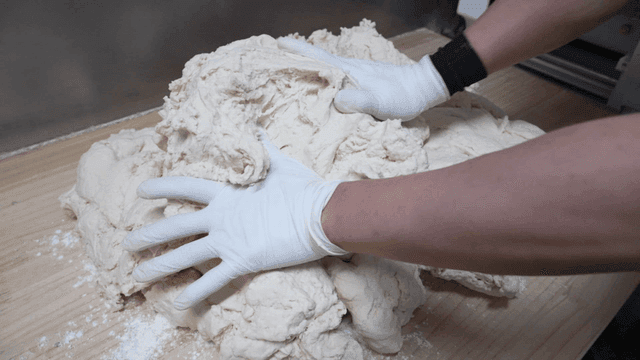 나무 도마 위에 반죽을 올리는 손