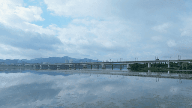Calm river with a bridge and mountains