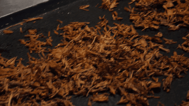 Dried enoki mushrooms spread out on black tray