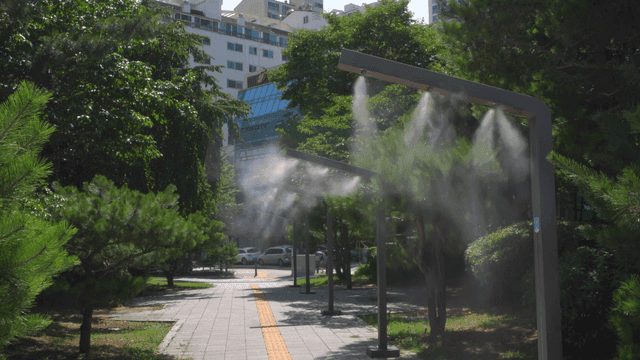 맑은 날의 도시 공원과 분무 시스템