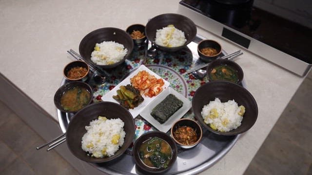 Table of chestnut rice and spinach soup with side dishes such as kimchi and laver