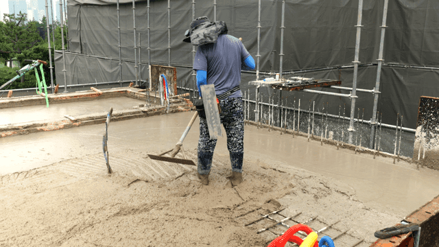Worker smoothing concrete on a building site
