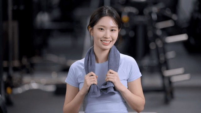 Young woman facing forward with a towel around his neck at gym