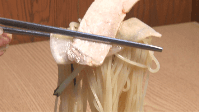 각종 재료와 함께 집은 밀면 한 젓가락