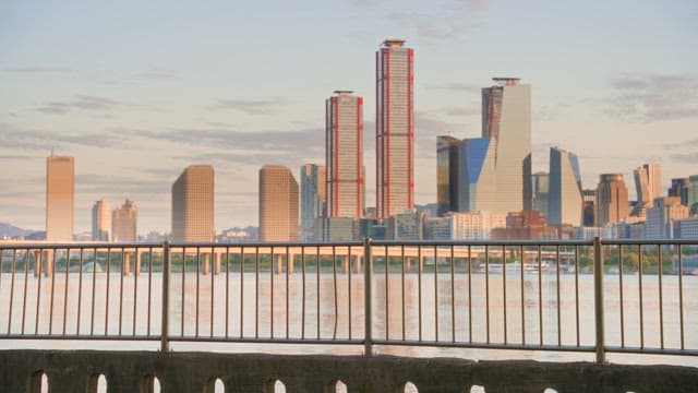 도시 풍경을 배경으로 강변을 걷는 커플