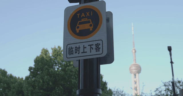 Taxi sign with a city tower in the background