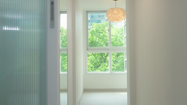 Woman walking through house with bright interior holding storage box