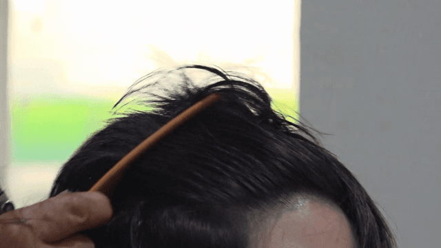 실내에서 머리를 자르는 사람