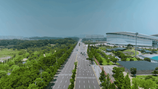 Wide road with modern sports stadiums and greenery