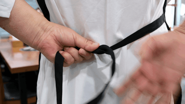 Back view of person tying apron in restaurant