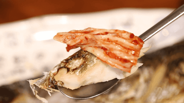 Grilled fish with kimchi on a spoon