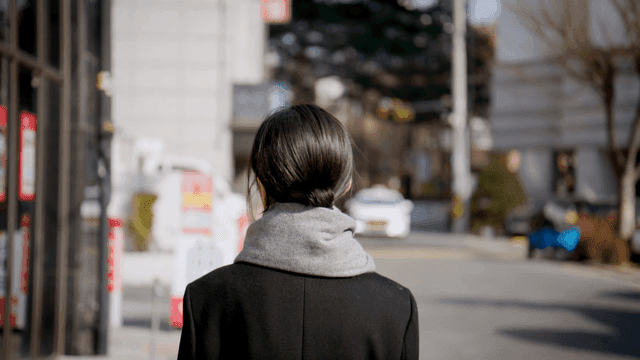Back view of woman walking down winter street