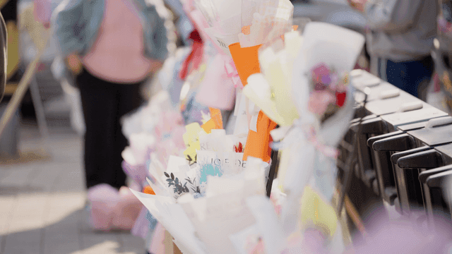 사람들이 다양한 꽃다발을 구경하는 모습