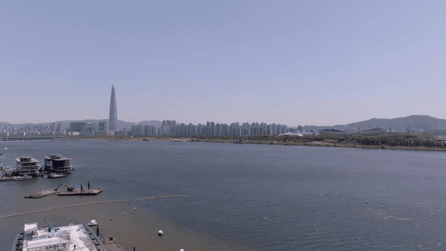 A city skyline with a river and skyscraper