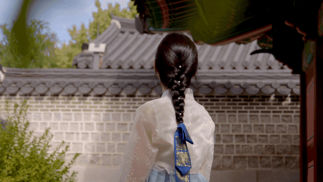 Woman in hanbok at a traditional Korean house