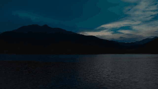 A tranquil lake at dusk with mountains