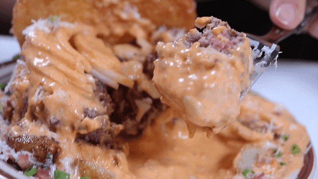 포크로 치즈 소스에 듬뿍 찍는 버거