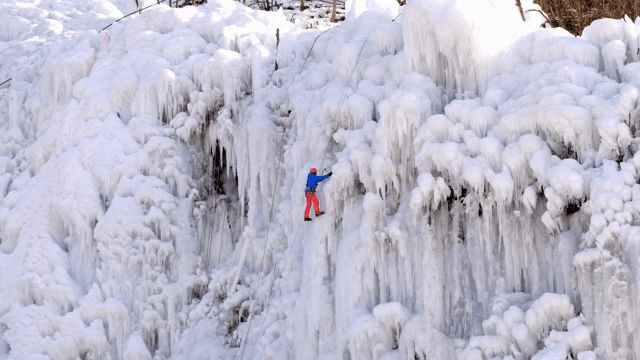 얼어붙은 폭포를 오르는 아이스 클라이머