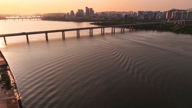 도시 배경의 고요한 강 위 일몰