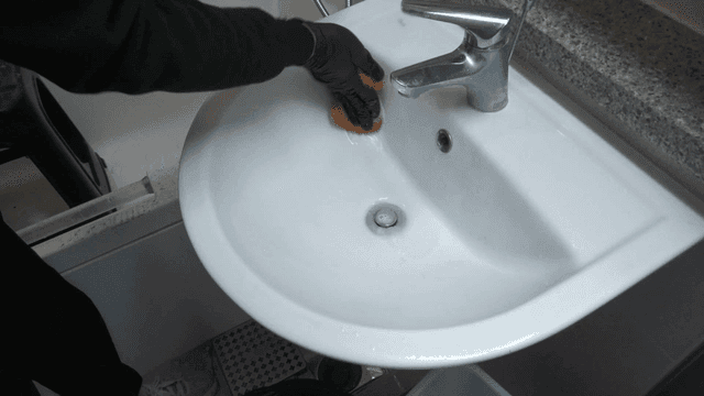 장갑을 끼고 욕실 세면대 청소