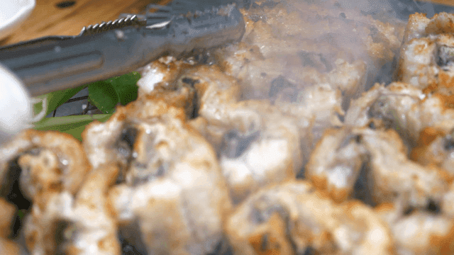 Eels grilled with green onions over charcoal fire