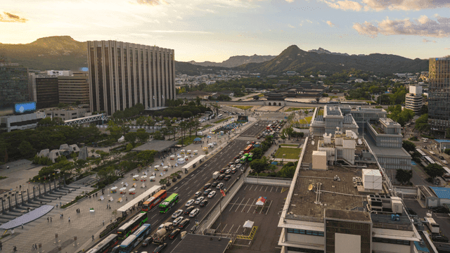 Bustling city landscape in front of palace with mountains in background