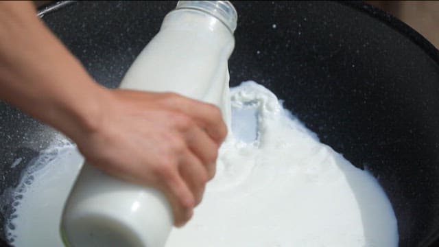 Pouring milk into a black pan