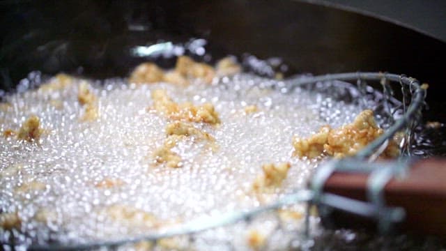 Fried pork for sweet and sour pork being cooked in hot oil