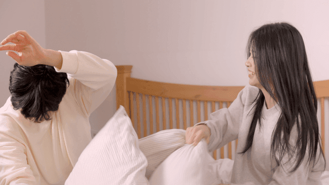 베개 싸움을 하는 장난스러운 커플