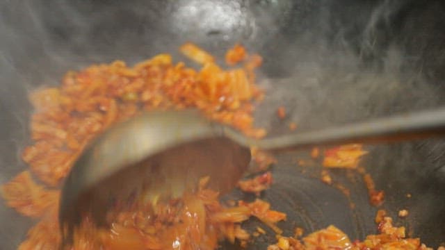 Stir-frying kimchi in a hot wok