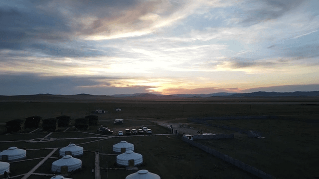 유르트가 있는 광활한 풍경의 일몰