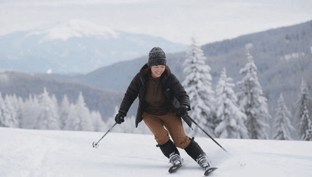 눈 덮인 산에서 스키를 타는 여성
