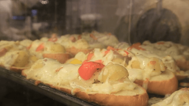 오븐에서 구워지는 샐러드가 올라간 바게트