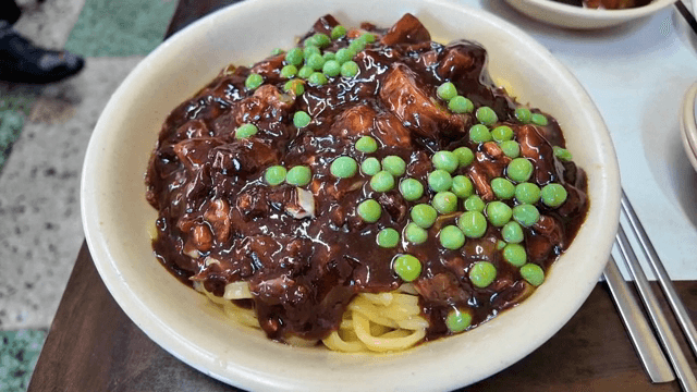 완두콩이 올려진 짜장면 한 그릇
