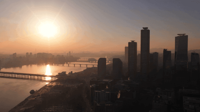 Sunrise over a city skyline with river
