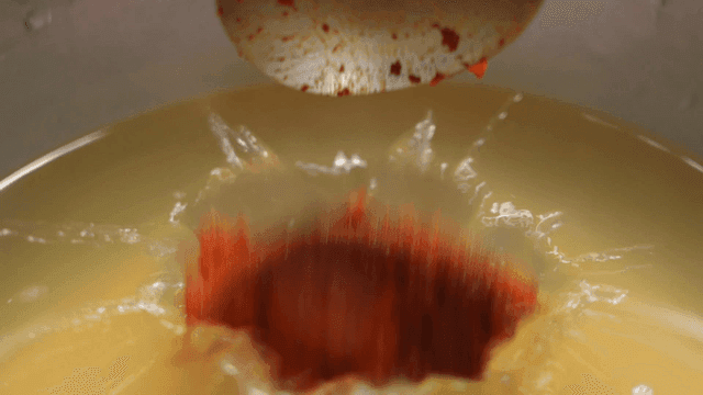 Red pepper paste being added to broth